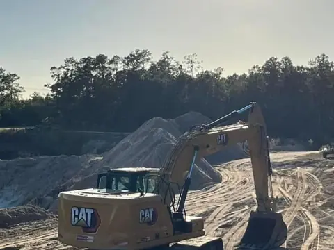 Excavator working a stockpile — Coastal Clearing & Debris, Brunswick County NC