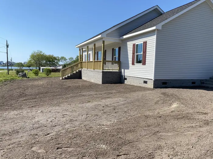 Waterfront yard graded and shaped around a home near Holden Beach
